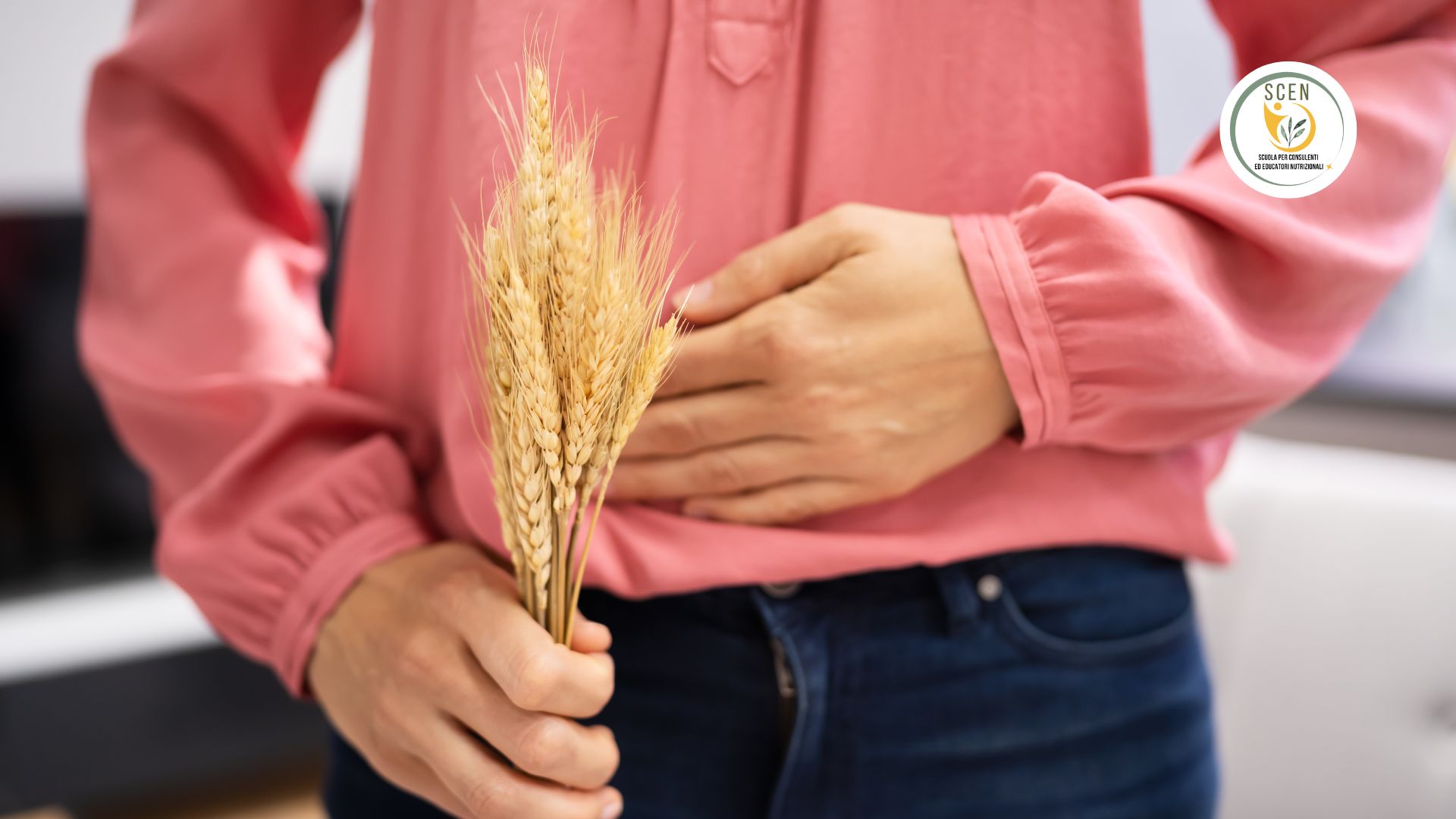 Una donna che tiene in mano del grano, mentre con l'altra si tocca la pancia